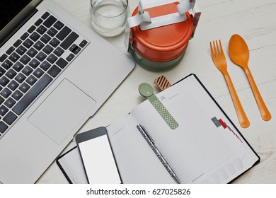 Fast Lunch Break In The Office With Colored Asian Styled Food Containers And Typical Business Accessories - Laptop, Cell And Diary