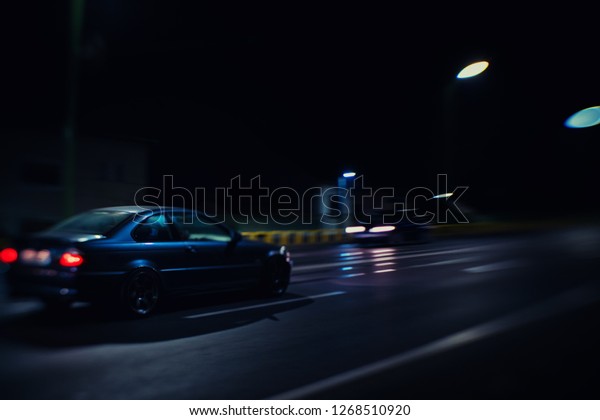 Fast\
modern business luxury prestige car lit in the\
dark