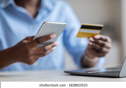 Fast Money Transfers. Unrecognizable Black Businesswoman Using Smartphone And Credit Card For Online Payments, Using Mobile Banking, Paying Bills In Internet, Cropped Image, Closeup Shot