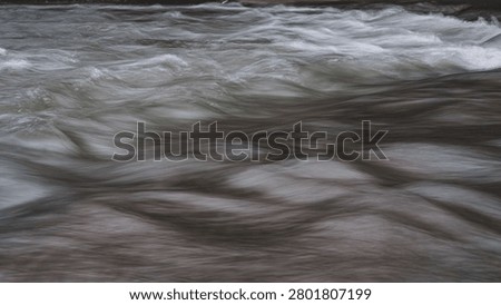 Fast moving and flowing river, powerful stream running through the woods