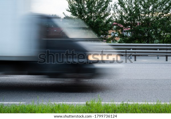 Fast\
moving motion blurred car silhouette on a\
road