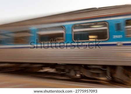 Fast moving passenger train captured with motion blur effect traveling on the tracks during the day