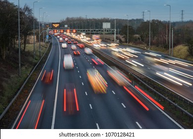 Fast moving traffic drives along the M42 in Warwickshire during evening rush hour, leaving traffic light trails as the vehicles are controlled using Active Traffic Management for each motorway lane - Shutterstock ID 1070128421