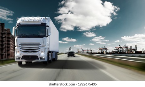 Fast moving truck with full lighting on a motorway with port for container ships. Water, cranes and warehouses with an imposing sky. 