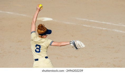 A Fast Pitch Softball Pitcher Is In Full Wind Up Pitching The Ball To Home Plate - Powered by Shutterstock