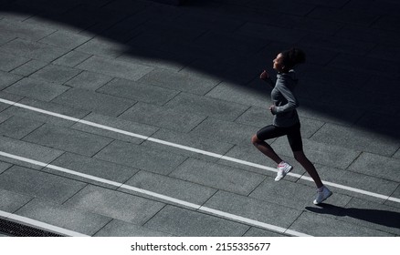 Fast Runner. Young African American Woman In Sportive Clothes Have Workout Outdoors At Daytime.