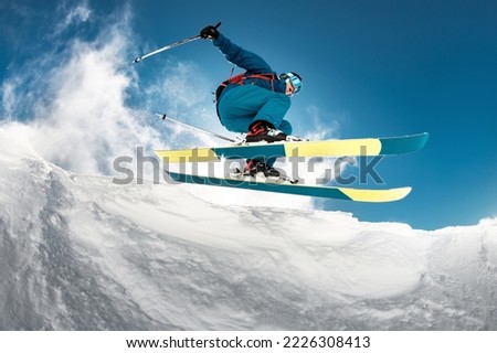 Fast skier is jumping over camera. Close-up photo of jump.