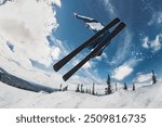 Fast skier without ski poles jumps against blue sky