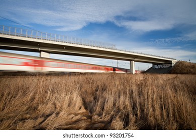 Fast train passing under a bridge on a lovely summer day (motion blurred image)