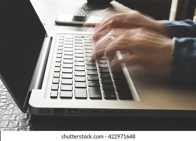 Fast typing woman on laptop. Blurred hands typing