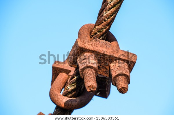 Fastening clamp on the steel cable of the\
bridge. Connecting elements of\
construction.