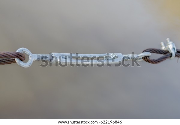 Fastening clamp on the steel cable of the bridge.\
Connecting elements of construction. Steel wire rope whit\
connection fasteners 