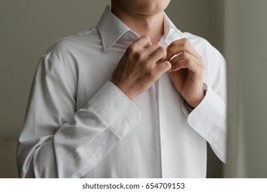 Fastens the button at the shirt, Bridegroom's fees, Fiance in shirt, wedding day - Powered by Shutterstock