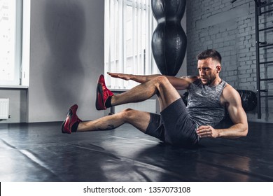 Faster and stronger. The athlete trains hard in the gym. Stretching and warm-up sportsman doing special exercises for muscles before work his body out. Fitness, healthy life and self-control concept.