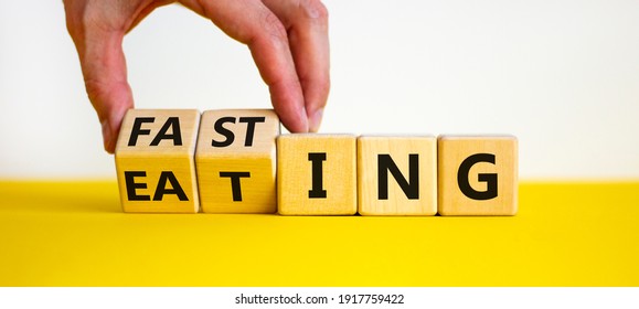 Fasting or eating symbol. Doctor turns wooden cubes and changes the word 'eating' to 'fasting'. Beautiful white background, copy space. Healthy eating, medical and time to fasting concept. - Shutterstock ID 1917759422