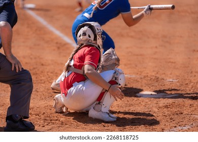 Fastpitch softball catcher waiting for pitch with batter showing bunt.
				