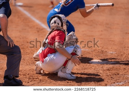 Fastpitch softball catcher waiting for pitch with batter showing bunt.
