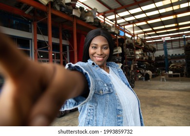 Fat African American Woman Modeling Making Selfie Camera Photo. Old Machine Auto Parts In Warehouses. Auto Mechanic Car Service, Repair And Maintenance Concept.