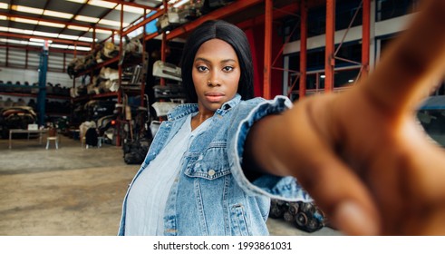 Fat African American Woman Modeling Making Selfie Camera Photo. Old Machine Auto Parts In Warehouses. Auto Mechanic Car Service, Repair And Maintenance Concept.