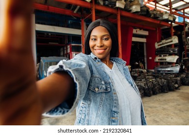 Fat African American Woman Modeling Making Selfie Camera Photo. Old Machine Auto Parts In Warehouses. Auto Mechanic Car Service, Repair And Maintenance Concept.