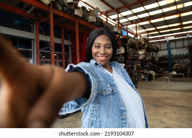 Fat African American Woman Modeling Making Selfie Camera Photo. Old Machine Auto Parts In Warehouses. Auto Mechanic Car Service, Repair And Maintenance Concept.