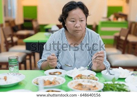Fat Asian woman ready to eat her Thai meal at table in office