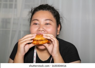 Fat asian woman wearing Black t-shirt and choosing to eat Berger.