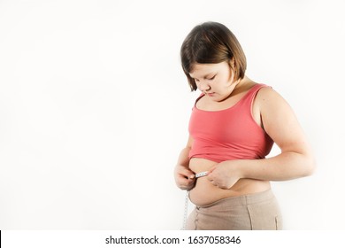 fat chubby kid girl with centimeter tape measures waist volume of abdomen, sadness and surprise. Children obesity concept, overweight control. White background