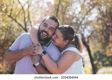 A Fat Couple Posing In A Park