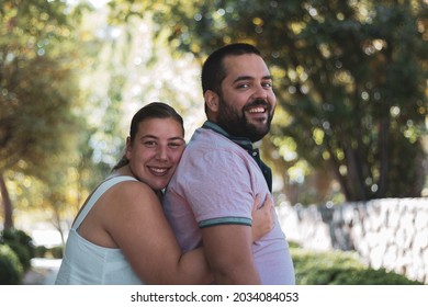 A Fat Couple Posing In A Park