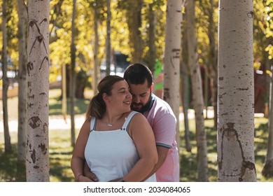 A Fat Couple Posing In A Park