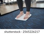 Fat diet and scale feet standing on electronic scales for weight control. Measurement instrument in kilogram for a diet control