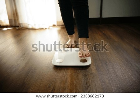 Fat diet and scale feet standing on electronic scales for weight control.	