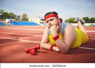 Fat Funny Man Lying Down Resting On The Track In The Stadium