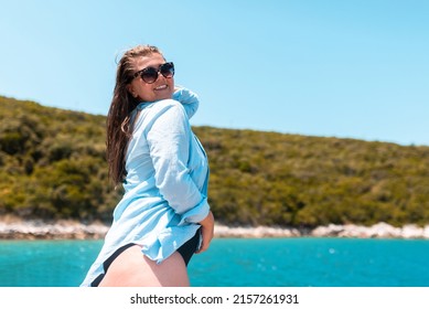 A fat girl enjoys her vacation. In the background the beach and the sea. High quality photo