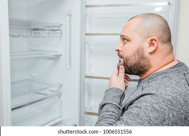 Fat Hungry Man Is Looking For A Food Into Empty Fridge