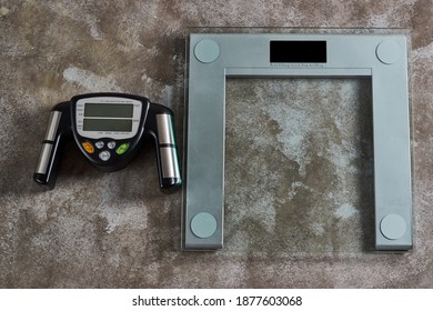 A Fat Loss Monitor And Digital Scales On A Grunge Background