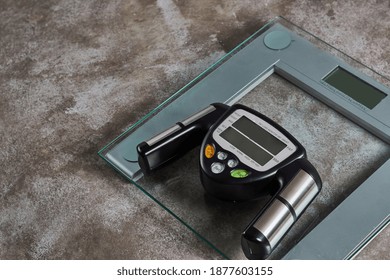 A Fat Loss Monitor And Digital Scales On A Grunge Background