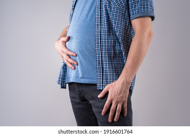 Fat Man With Bloating And Abdominal Pain, Overweight Male Body On Gray Background, Studio Shot
