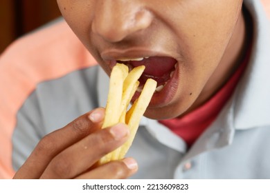 A Fat Man Eating French Fries While Sited 