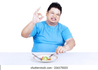 Fat man eating salad for losing weight