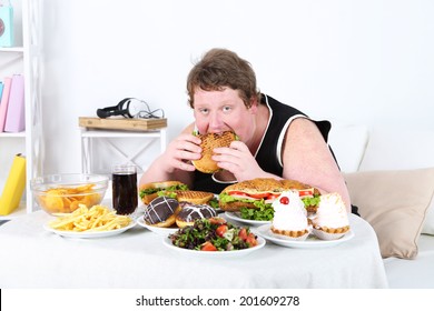 Fat man eating a lot of unhealthy food, on home interior background  