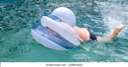 A Fat Man Is Floating On An Inflatable Circle In The Pool