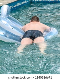 A Fat Man Is Floating On An Inflatable Circle In The Pool