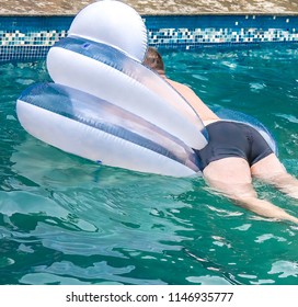 A Fat Man Is Floating On An Inflatable Circle In The Pool