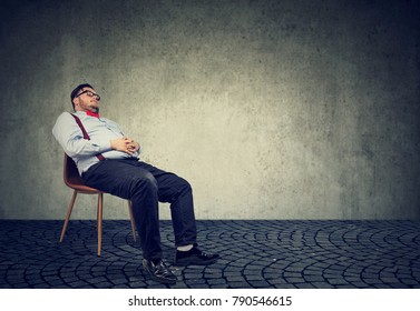 Fat man in formal clothing sitting on chair and sleeping in dream. 