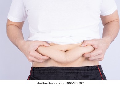 Fat Man Holding Excessive Fat Belly, Overweight Fatty Belly Isolated Grey Background. Diet Lifestyle, Weight Loss, Stomach Muscle, Healthy Concept.