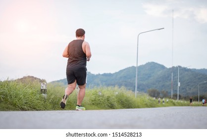 Fat man is jogging on road. Concept of Exercise, weight loss. 