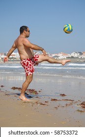 A Fat Man Playing With A Ball On The Beach