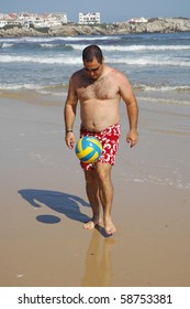 A Fat Man Playing With A Ball On The Beach